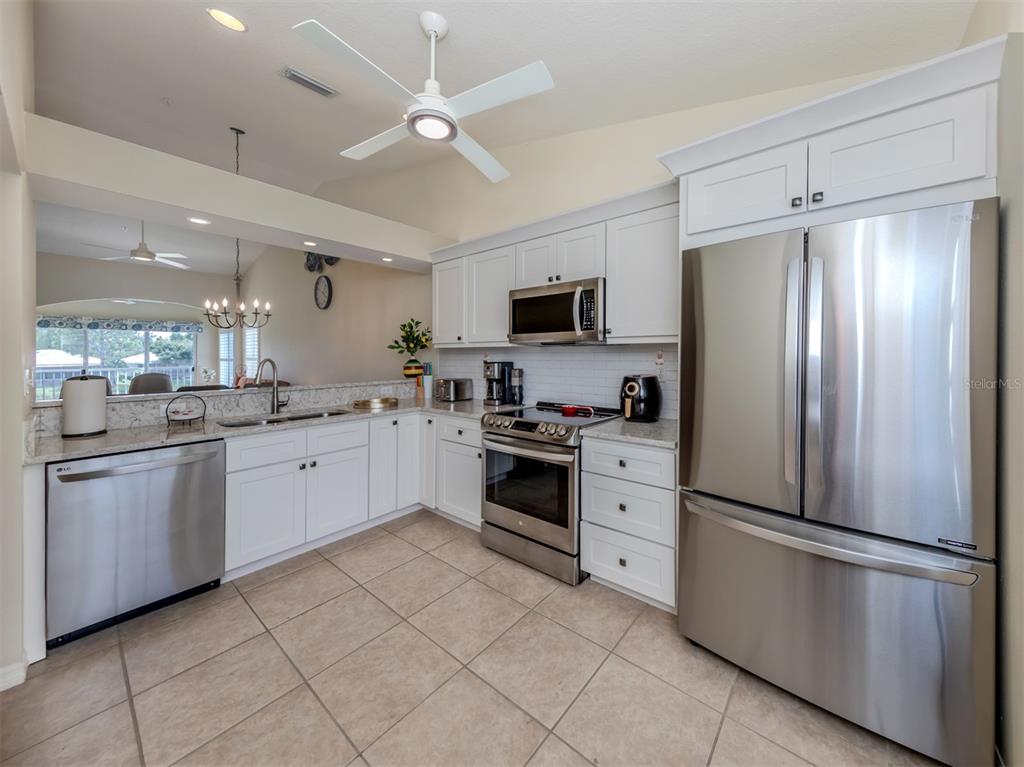 901 Addington Court, Unit 203 Venice, FL 34293 - Photo 10 of 61 a kitchen with white cabinets stainless steel appliances and a refrigerator