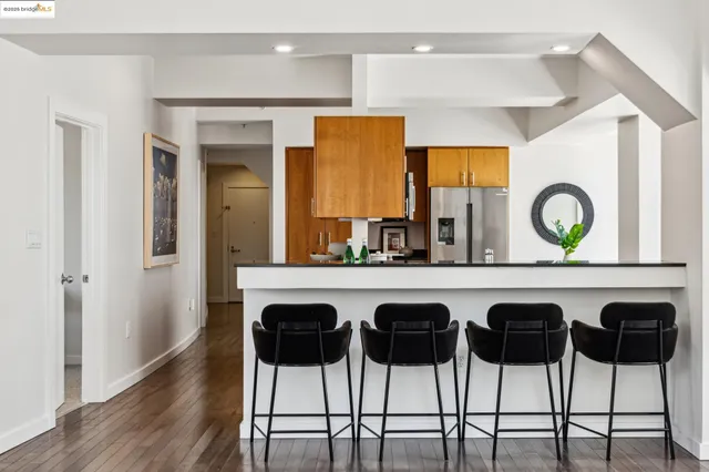 a kitchen with stainless steel appliances a dining table chairs and wooden floor