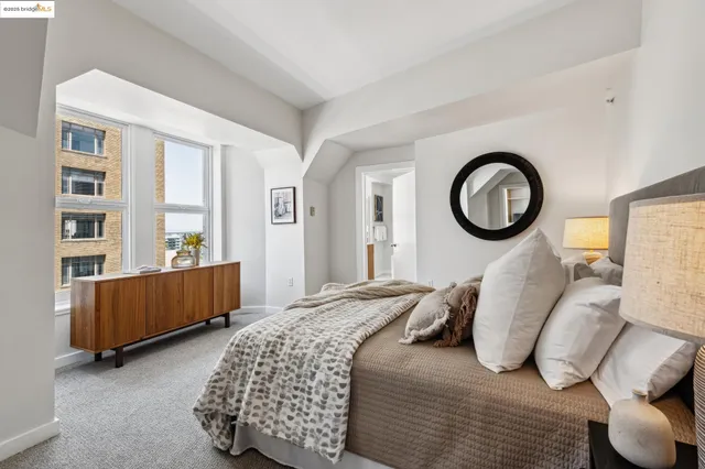 a bedroom with a bed and a lamp on dresser