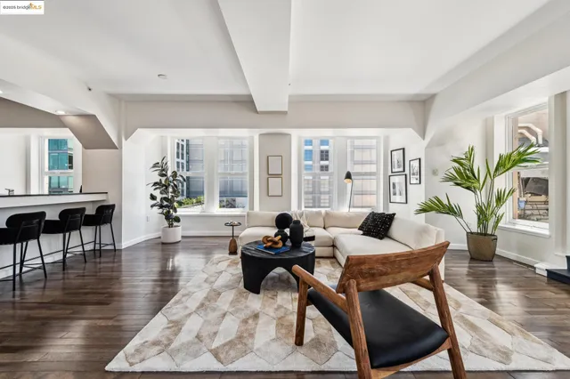 a living room with furniture a flat screen tv and a floor to ceiling window
