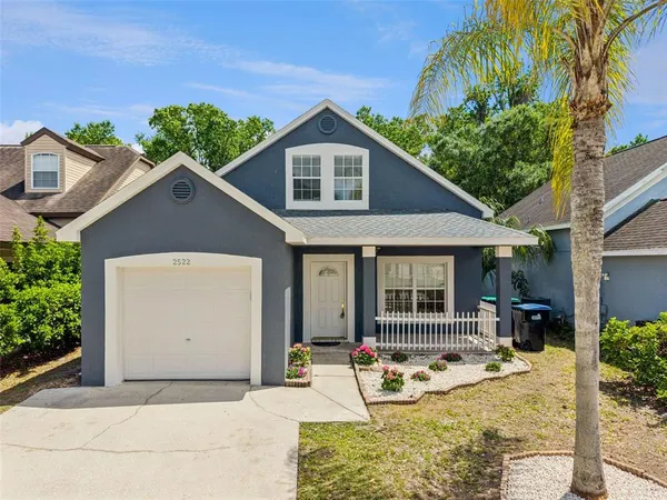 a front view of house with yard and trees in the background