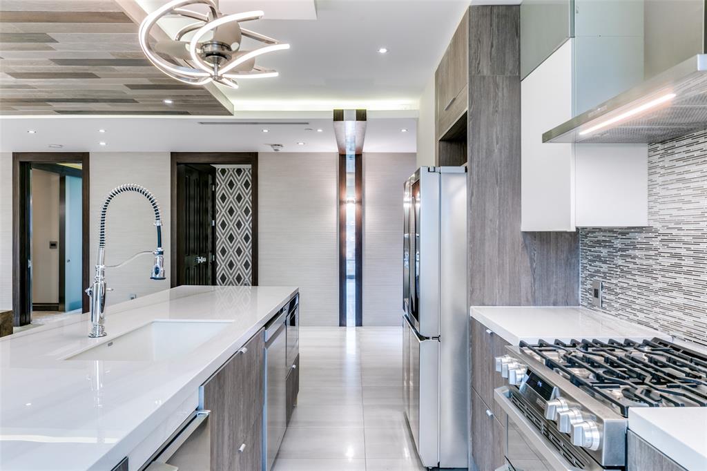 4005 Gaston Avenue, Unit PH2 Dallas, TX 75246 - Photo 6 of 33 Kitchen featuring stainless steel appliances, modern cabinets, wall chimney range hood, a sink, and light countertops