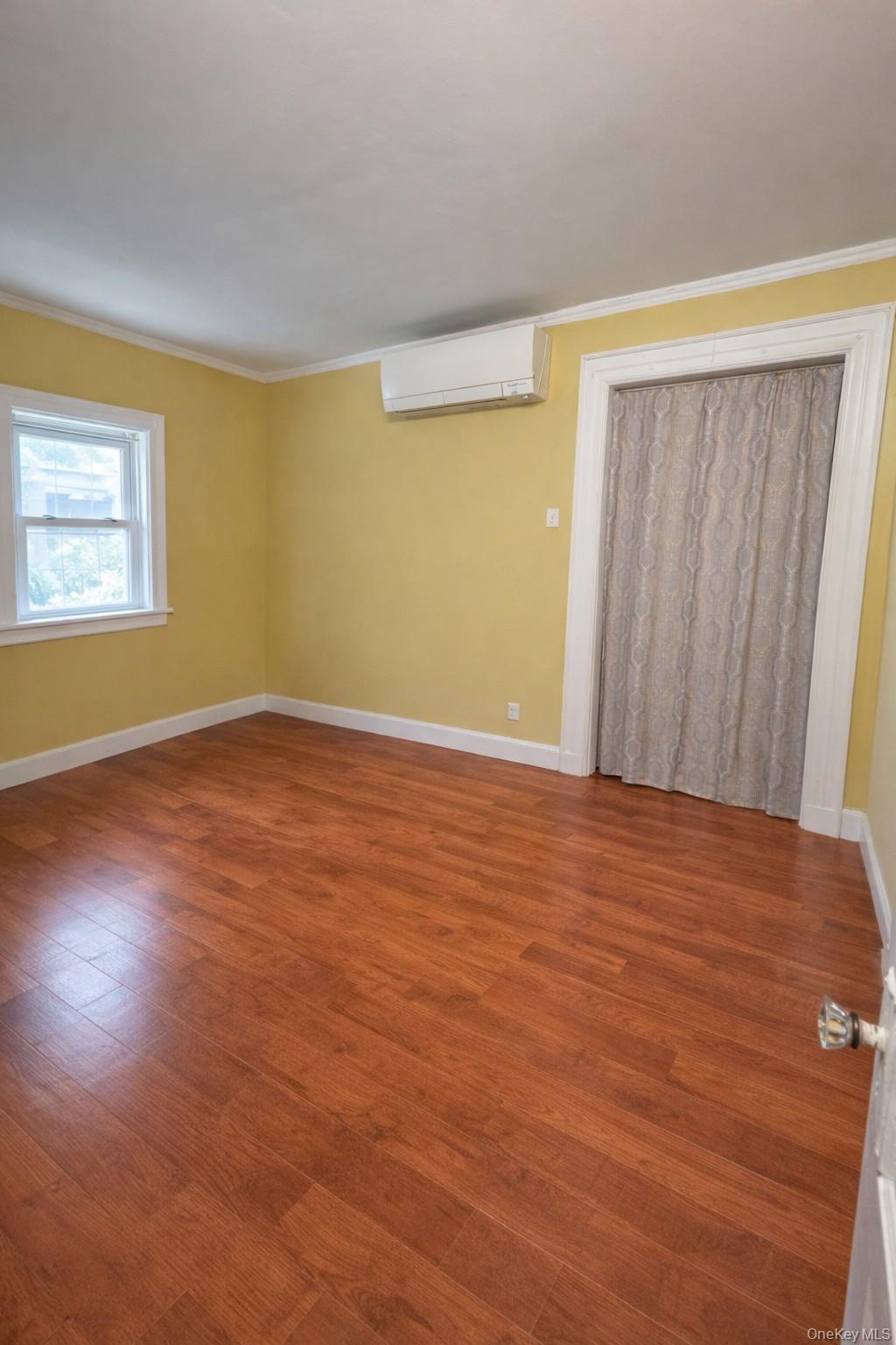 41-31 Hampton Street Queens, NY 11373 - Photo 5 of 23 a view of an empty room with wooden floor and a window