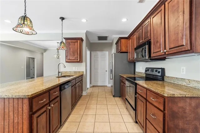 a kitchen with stainless steel appliances granite countertop a sink and a stove