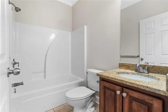 a bathroom with a granite countertop sink a toilet and shower