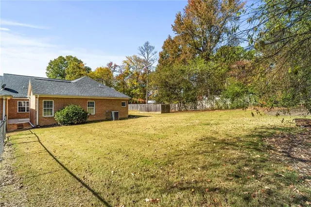a front view of house with yard and trees in the background