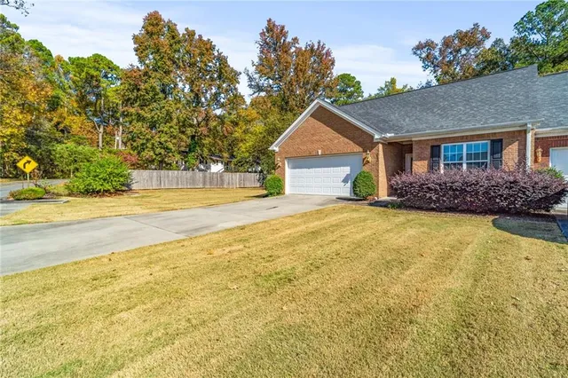 a front view of house with yard and trees in the background