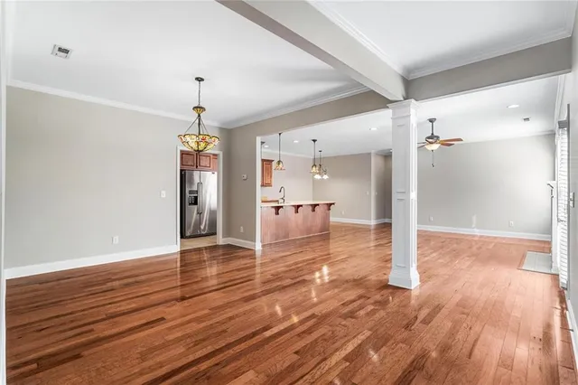 a view of a hallway with wooden floor and a chandelier