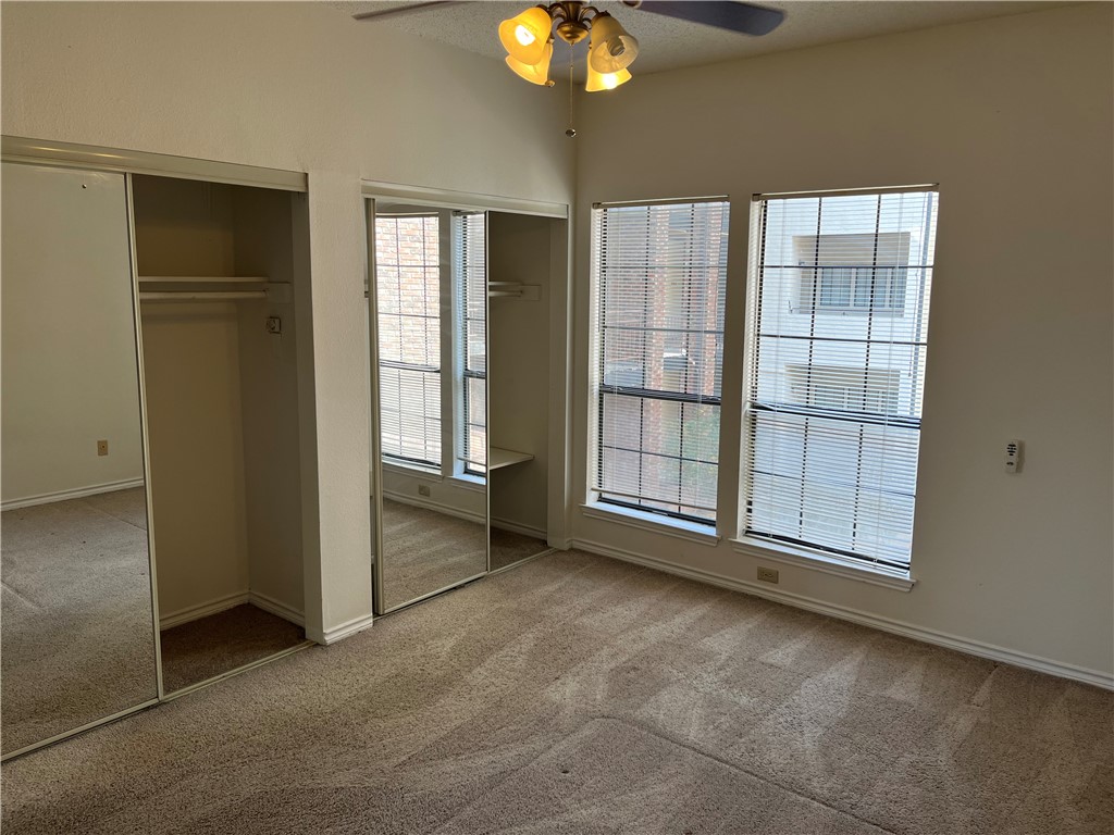 3001 Cedar Street, Unit A214 Austin, TX 78705 - Photo 8 of 17 an empty room with chandelier fan and windows