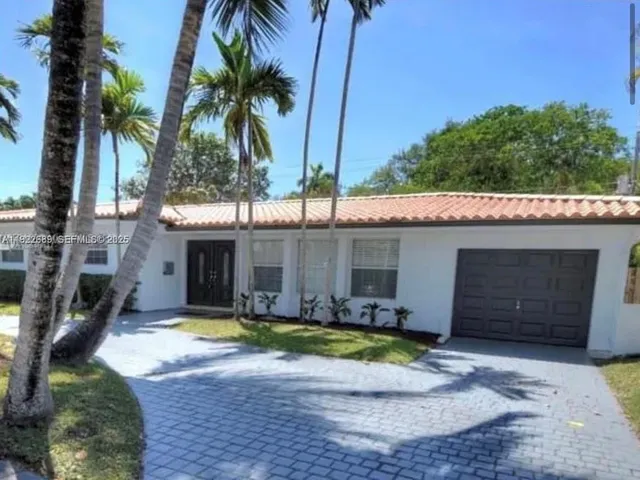 a view of a house with a yard and potted plants