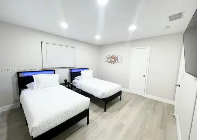 a bedroom with two beds and a night stand