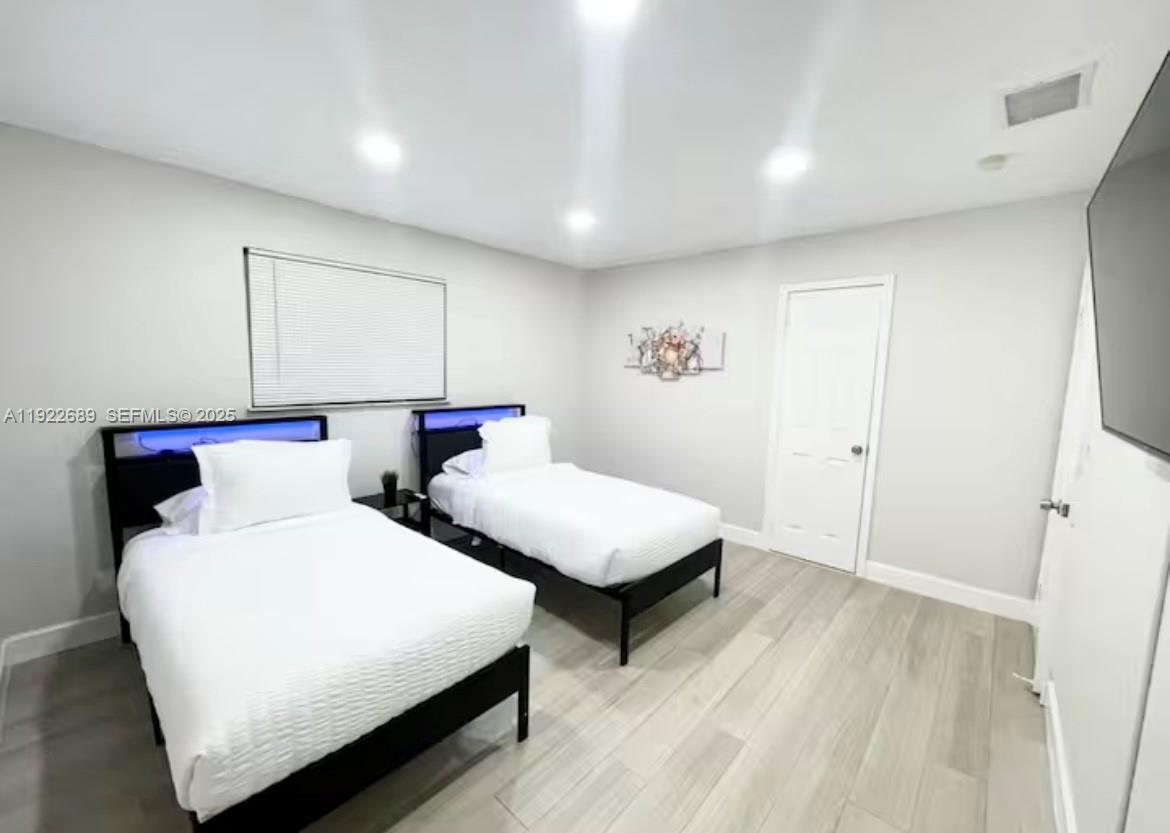 2080 Northeast 205th Street Miami, FL 33179 - Photo 13 of 24 a bedroom with two beds and a night stand