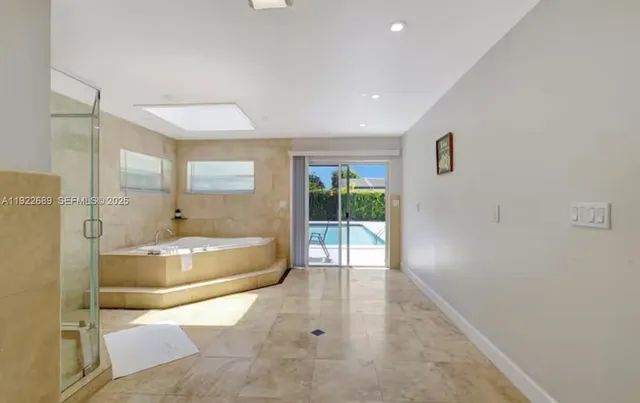 a spacious bathroom with a tub shower and window