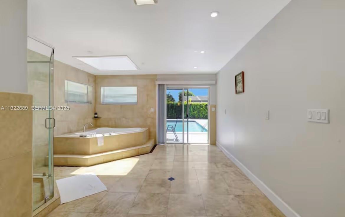 2080 Northeast 205th Street Miami, FL 33179 - Photo 14 of 24 a spacious bathroom with a tub shower and window