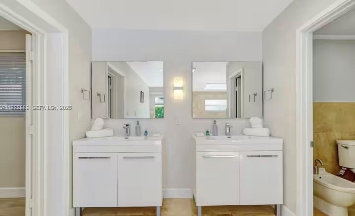 2080 Northeast 205th Street Miami, FL 33179 - Photo 16 of 24 a bathroom with double vanity sink and a mirror