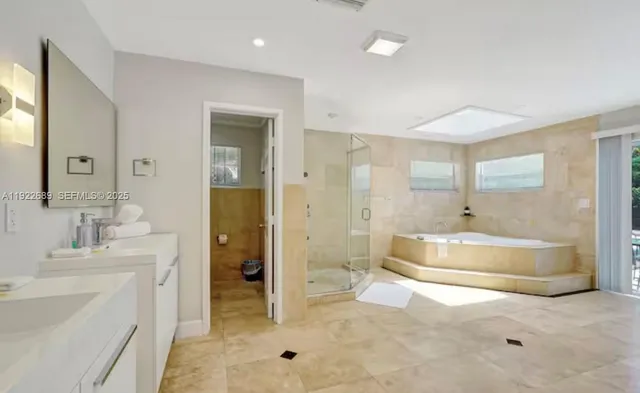a spacious bathroom with a tub sink shower and mirror