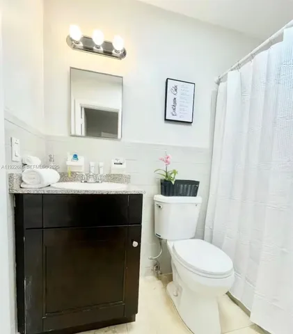 a bathroom with a sink vanity mirror and toilet