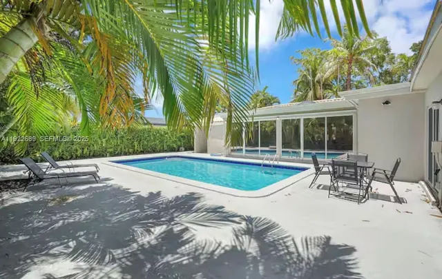 a swimming pool with outdoor seating and yard