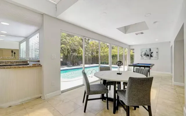 a dining room with furniture large windows and a chandelier