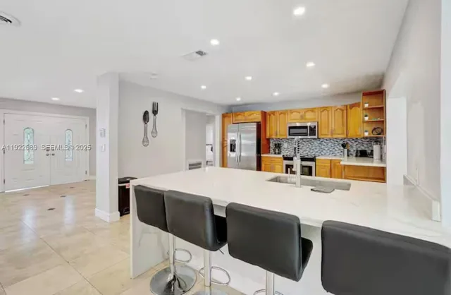 a kitchen with stainless steel appliances kitchen island granite countertop a sink and cabinets