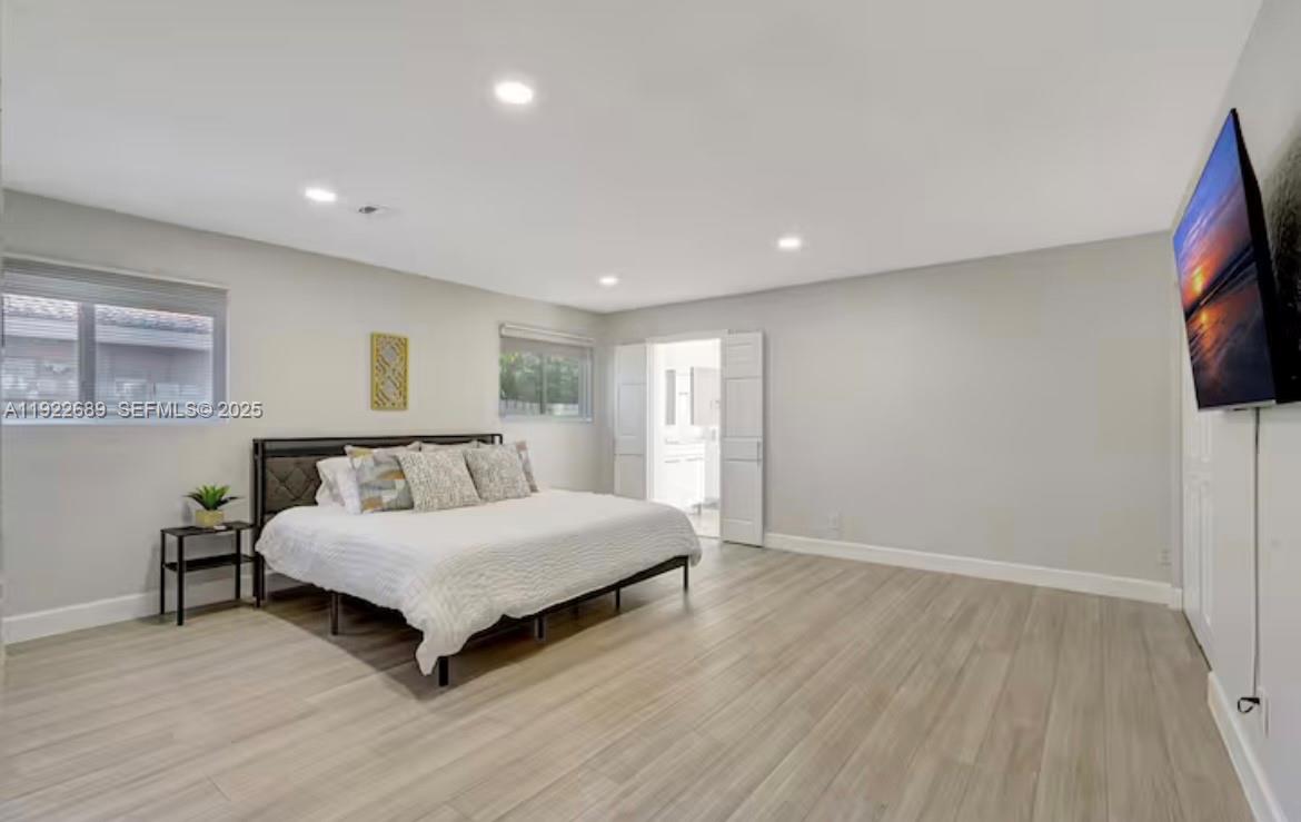 2080 Northeast 205th Street Miami, FL 33179 - Photo 10 of 24 a spacious bedroom with a bed and a flat screen tv