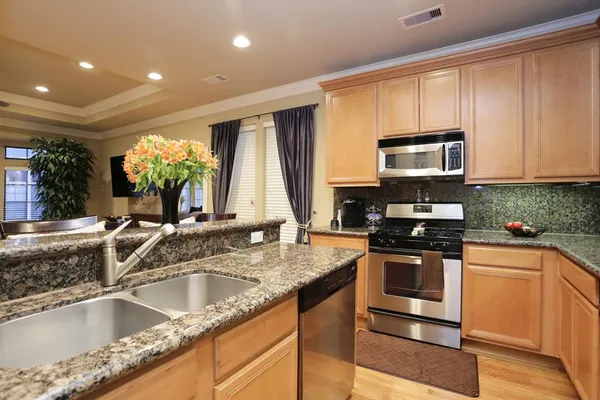 a kitchen with stainless steel appliances granite countertop a sink and a stove
