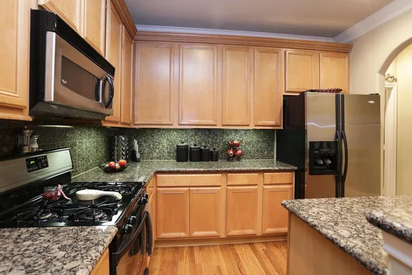 a kitchen with stainless steel appliances granite countertop a sink stove and refrigerator