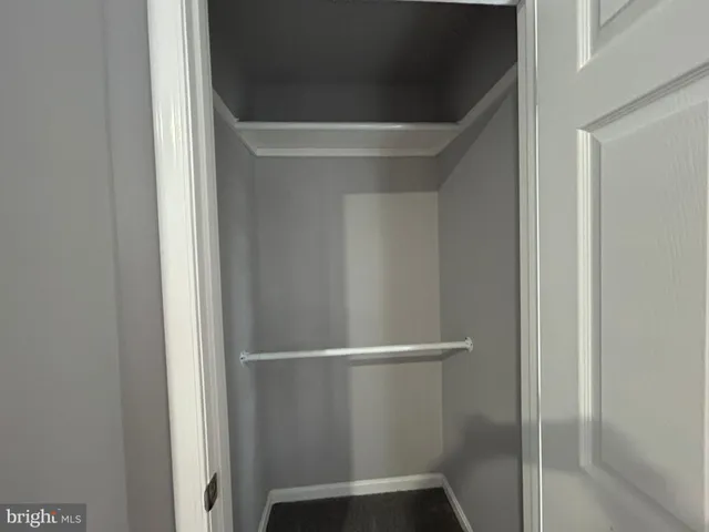 an empty room with fan and entrance