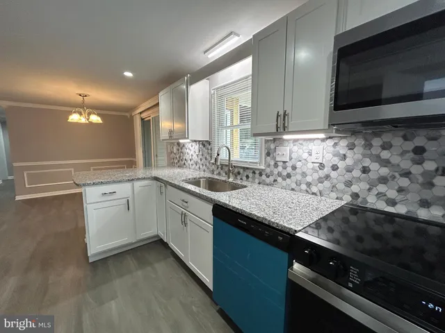 a kitchen with a sink stove and microwave
