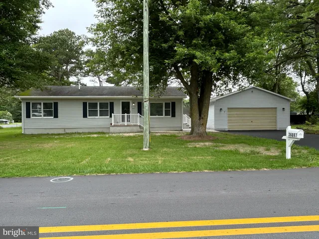 a house with green field in front of it