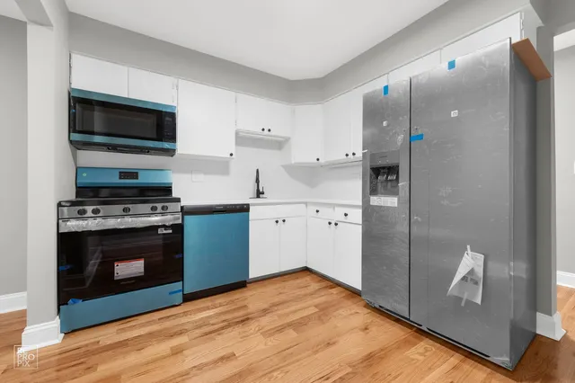 a kitchen with stainless steel appliances a stove a microwave and a refrigerator