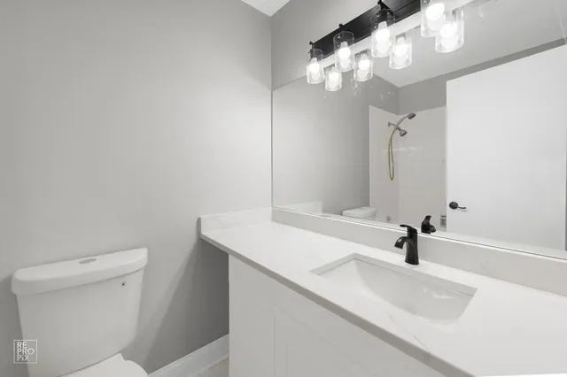 a bathroom with a sink a toilet and a mirror