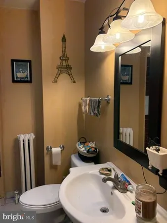 a bathroom with a sink a toilet and a mirror