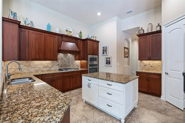 a kitchen with stainless steel appliances granite countertop a sink and a refrigerator