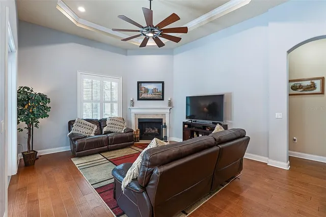 a spacious bedroom with a bed a dresser and wooden floor