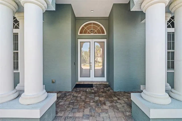 a living room with furniture and a large mirror next to a window