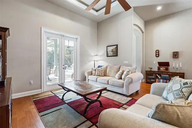 a living room with furniture kitchen view and a chandelier
