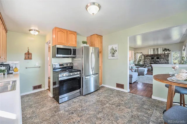 a kitchen with stainless steel appliances granite countertop a refrigerator sink and cabinets