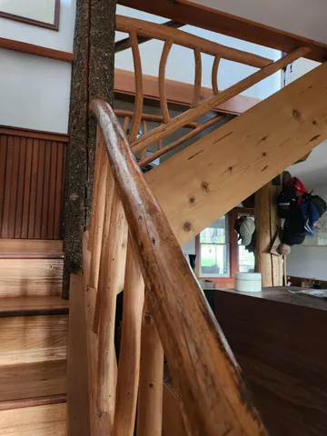 a view of a backyard with table and chairs potted plants and a large tree
