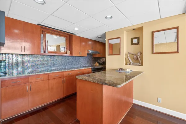 a kitchen with stainless steel appliances granite countertop a sink and a granite counter tops next to a window