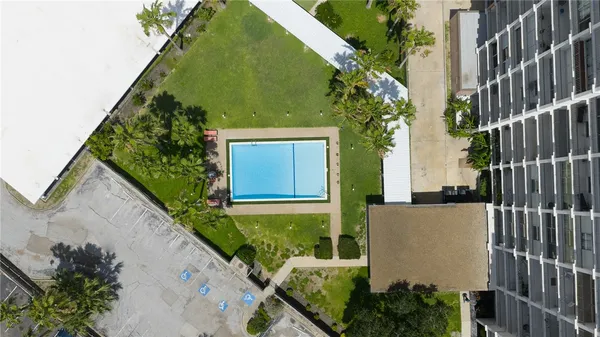 a view of a swimming pool with lawn chairs and a yard
