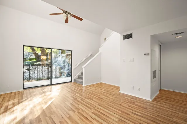 a view of a room with wooden floor and staircase