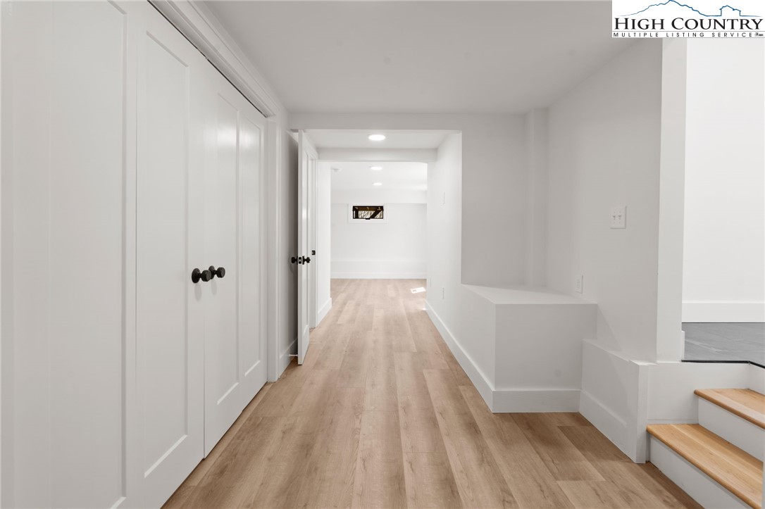 212 Chinkapin Ridge Road Seven Devils, NC 28604 - Photo 14 of 21 a view of a hallway with wooden floor and a bathroom