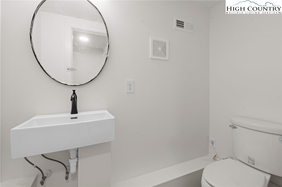212 Chinkapin Ridge Road Seven Devils, NC 28604 - Photo 17 of 21 a bathroom with a sink a mirror and a toilet