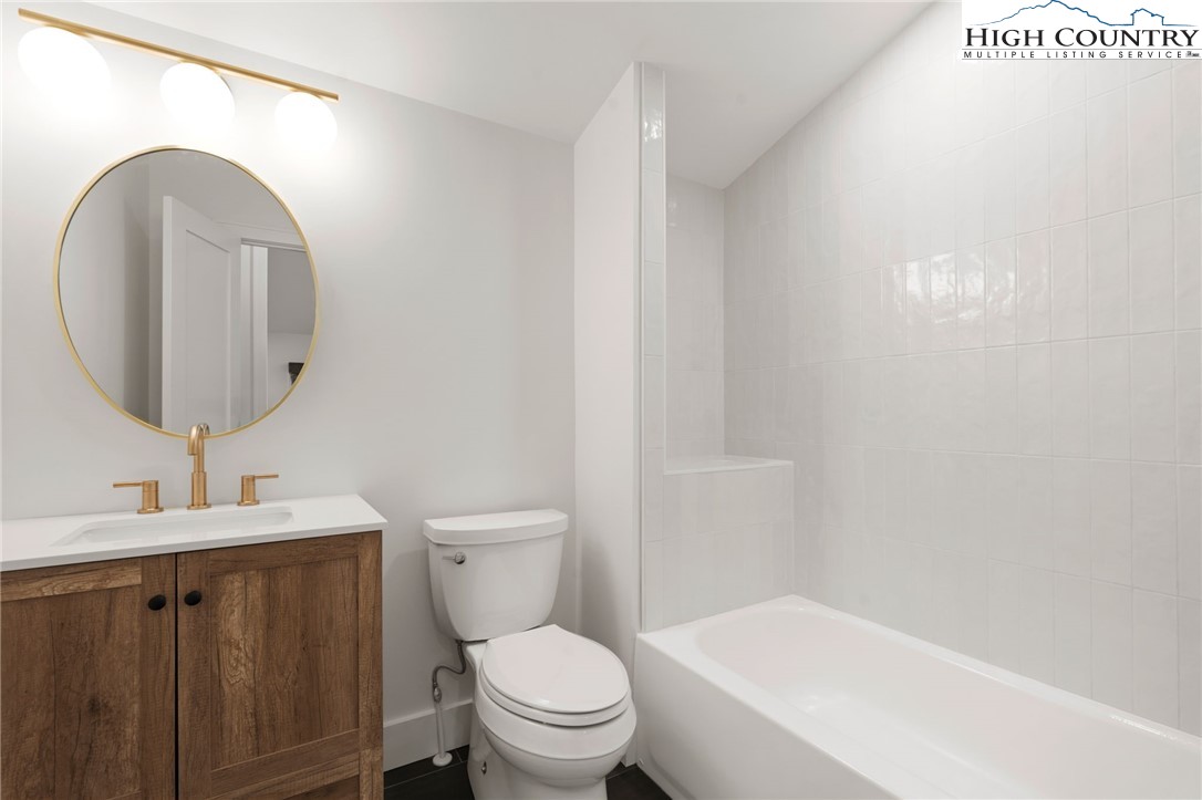 212 Chinkapin Ridge Road Seven Devils, NC 28604 - Photo 7 of 21 a bathroom with a toilet a sink and mirror