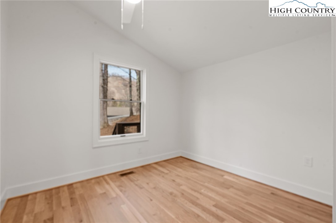 212 Chinkapin Ridge Road Seven Devils, NC 28604 - Photo 8 of 21 an empty room with wooden floor and windows