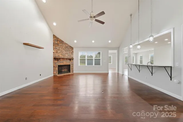 a view of empty room with wooden floor and a ceiling fan