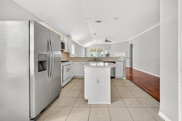a kitchen with stainless steel appliances granite countertop a refrigerator and a stove top oven