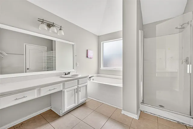 a spacious bathroom with a granite countertop sink mirror and a bathtub