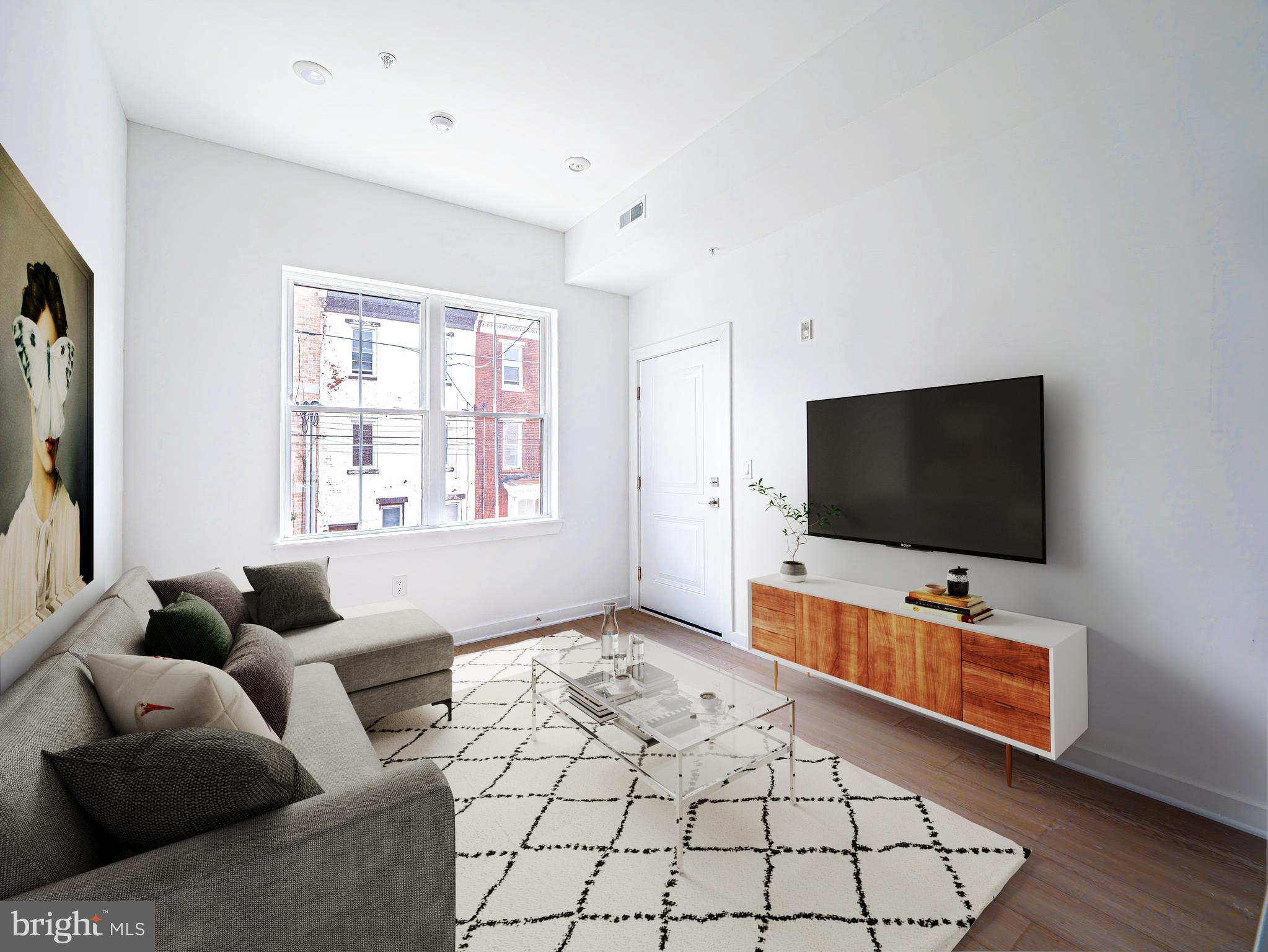 2403-2407 West Thompson Street, Unit 4 Philadelphia, PA 19121 - Photo 1 of 13 a living room with furniture and a flat screen tv